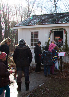 A group of people walking into Tudhop house. 