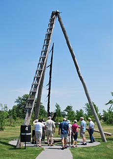 A group of people walking towards a oil rig.