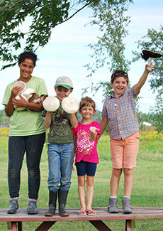 Children holding up mushrooms. 