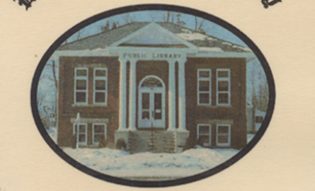 Photo of a red brick building with white pillars in the winter.